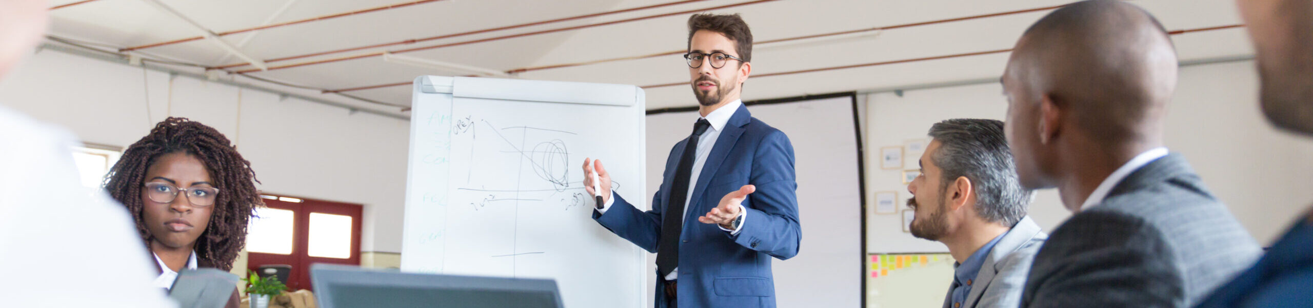 Low angle shot of speaker talking and looking at colleagues. Group of workers discussing ideas during presentation of new project at briefing. Business meeting concept