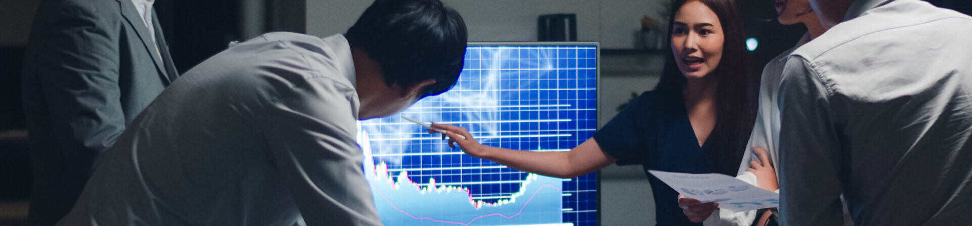 Asia businessmen and businesswomen meeting brainstorming ideas conducting business presentation project colleagues working together plan success strategy enjoy teamwork in small modern night office.